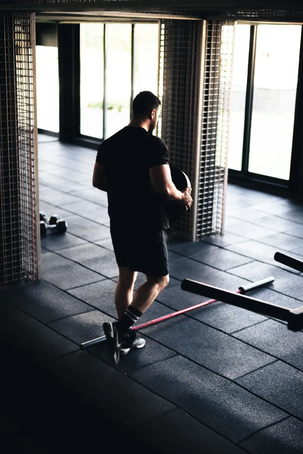 An athlete performing a resistance-band exercise while holding a weight plate