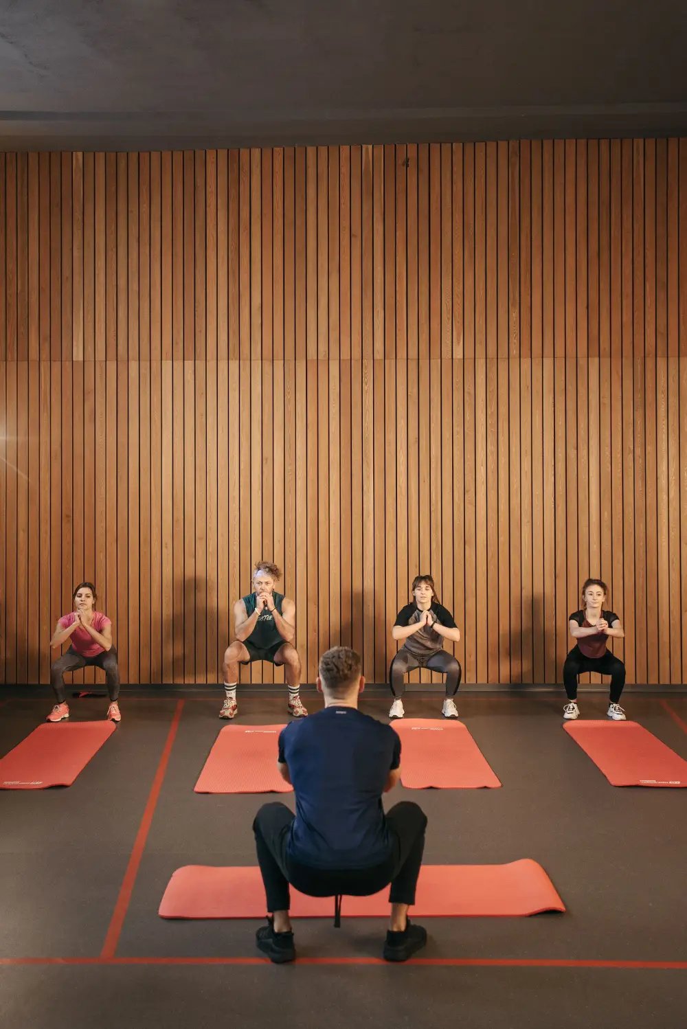 Coach leading a group through bodyweight squats