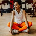 Athlete seated on a gym floor in workout clothes